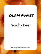 A close-up of fresh peaches with a card that has 'Glam Fumes - Peachy Keen' text on it.